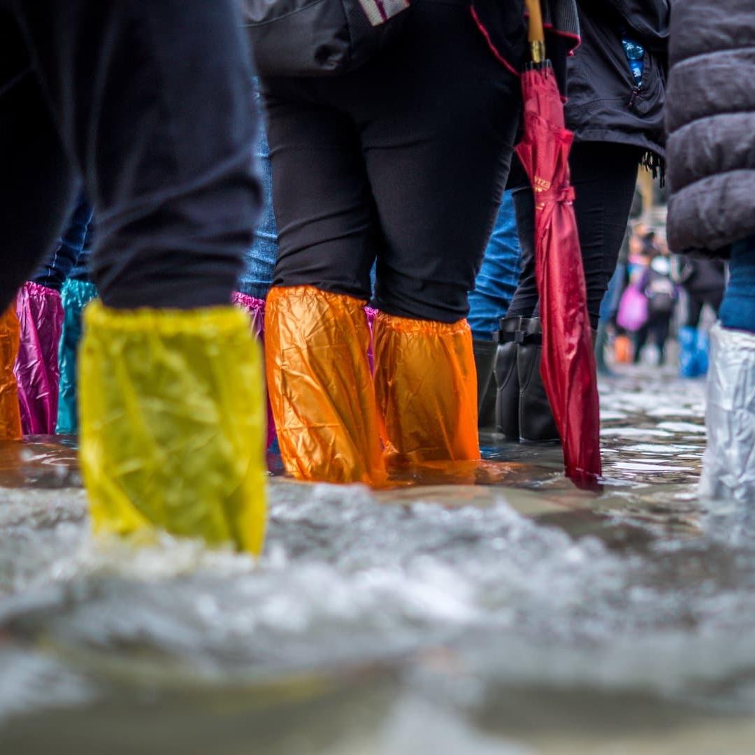 A group of people walking through flood water