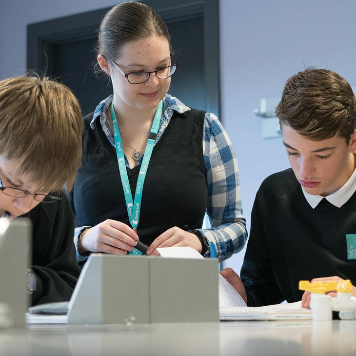 A teacher working with two students in a science lab at Kelvin School
